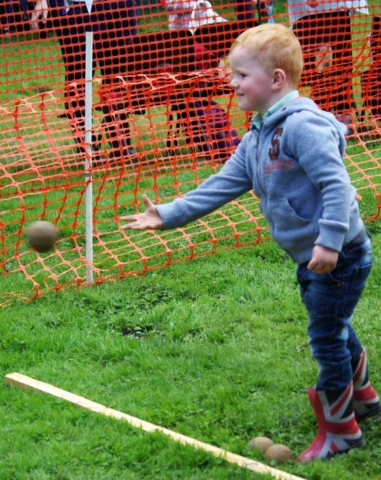 Young visitor throwing at the coconut shy Fair and Show 2015